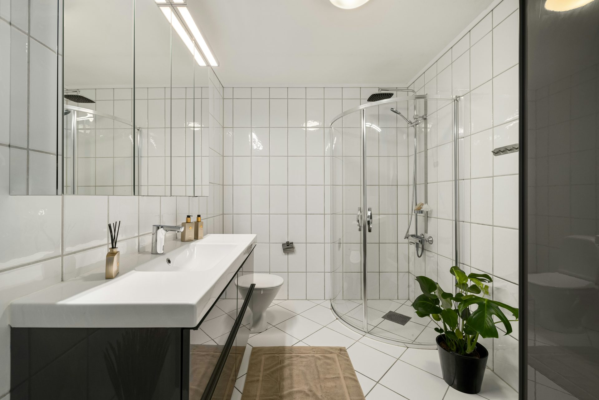 A bathroom with a sink, mirror, and shower